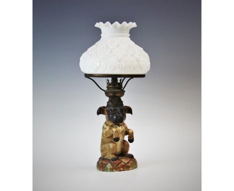 A Victorian novelty nursery oil lamp, probably German, the reservoir modelled as a begging pug dog with burner mounted into t