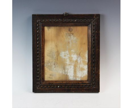A carved oak picture frame, 19th century, the stained portrait format frame with chiselled border freize and chamfered reveal