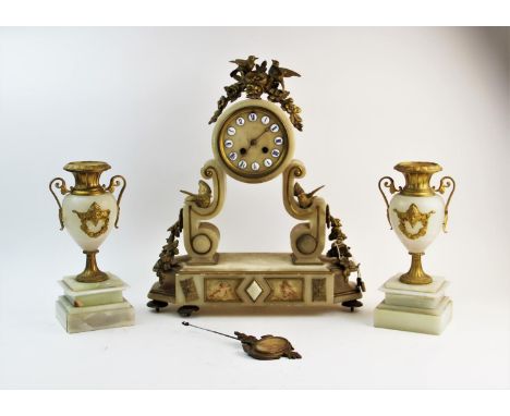 A late 19th century French alabaster and gilt metal clock garniture, the drum type clock surmounted with a crescent wreath an