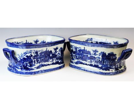 A pair of Victoria ware blue and white foot baths, each transfer decorated with architectural landscapes, applied with side l
