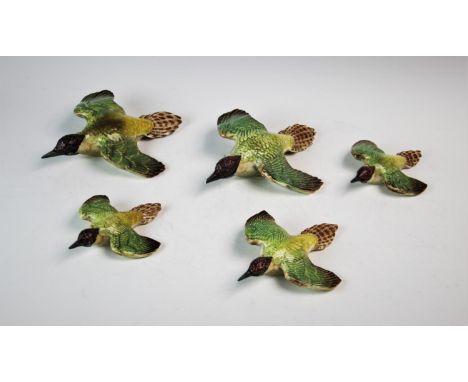 A set of three graduated Beswick flying woodpecker wall plaques, model numbers 1344-1, 1344-2, 1344-3, along with a second mo