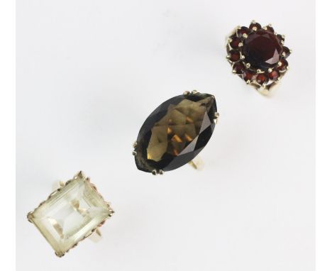 A citrine set dress ring, the step-cut citrine measuring approx. 18mm x 15mm, claw set in yellow metal to a plain polished sh