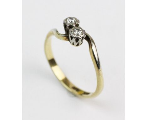 A two-stone diamond ring, comprising two brilliant cut diamonds in white metal illusion settings, continuing to  twist design