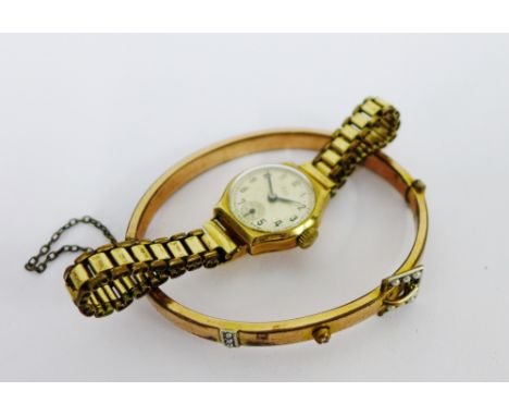 A lady's 9 carat gold cased wristwatch on gold plated bracelet strap together with a gold plated seed pearl set bangle (2) 