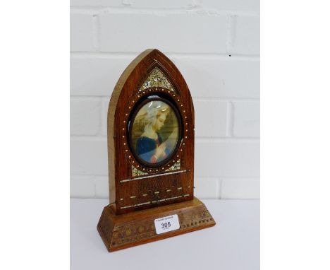 A portrait miniature contained within an inlaid arched top frame, 10 x 8.5cm