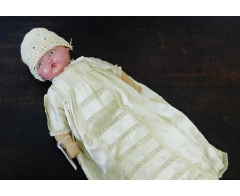 A vintage doll with celluloid head and fabric limbs