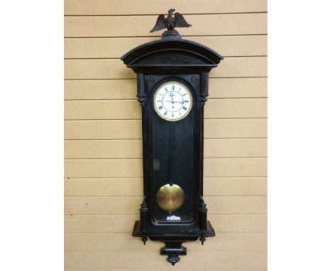 A VIENNA STYLE WALL CLOCK in an ebonized case, the single weight pendulum driven movement with white enamel dial set with Rom