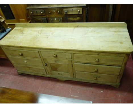 A GOOD ANTIQUE PINE DRESSER BASE, the railback two boarded top with rounded front corners, the lower section with an arrangem