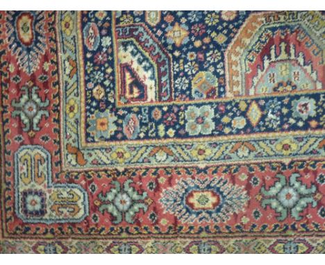 AN EASTERN WOOLLEN CARPET with repeat patterned triple border and multi panel central section on a vibrant background, 309 x 