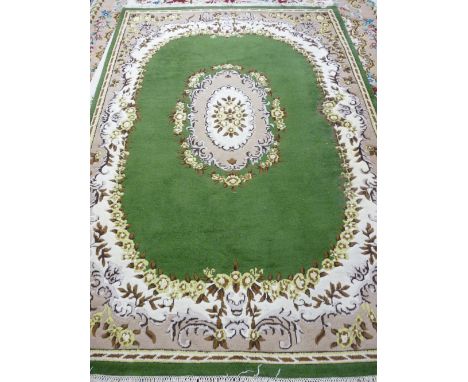 A GREEN GROUND INDIAN HAND KNOTTED WOOLLEN CARPET with cream and mushroom coloured border and central design, 280 x 185 cms a