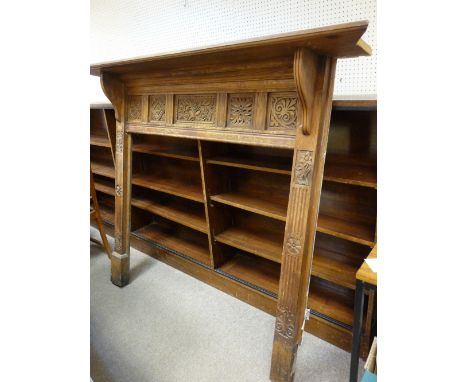 A LARGE CARVED OAK FIRE SURROUND with deep mantel shelf, the front having carved floral panels and side pillars with further 