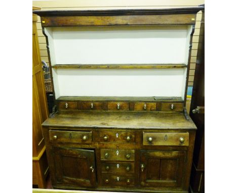 AN 18th CENTURY NORTH WALES OAK DRESSER with spice drawers, the two shelf rack with inverted cornice and shaped sides and fiv