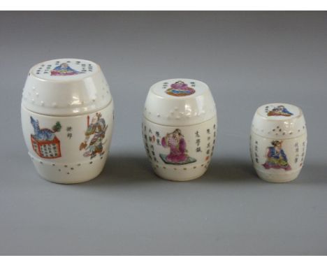 THREE CHINESE PORCELAIN GRADUATING BARREL SHAPED LIDDED POTS, circa 1900, decorated with various enamel painted figures and c