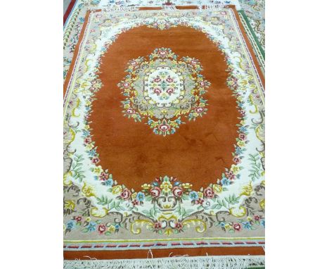 A 20th CENTURY INDIAN HAND KNOTTED CARPET with rust ground centre and border, brightly coloured central floral pattern and re