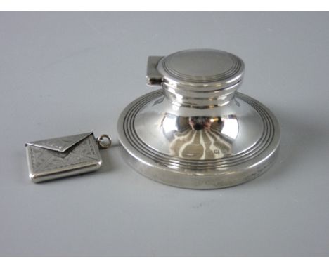 A HALLMARKED SILVER STAMP ENVELOPE and a capstan inkwell, the envelope with chased decoration, the inkwell with lidded top an