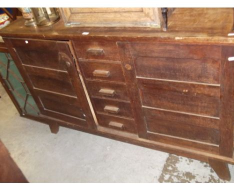 A Continental light oak sideboard with five central drawers and flank panelled doors