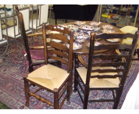 A 19th century oak ladder-back armchair with rush seat, another similar, a rush seated chair and a similar stool (4)