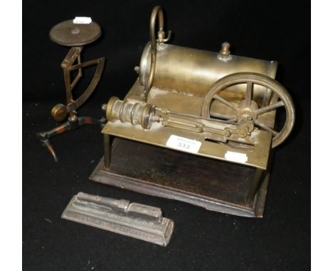A brass model stationary steam engine on a moulded mahogany base, together with a set of postal scales and a model of the Fly