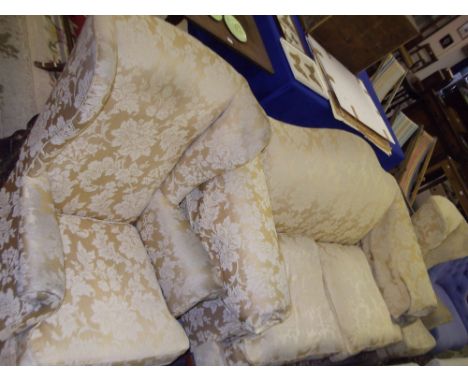 A George III style two seater sofa upholstered in gold material and a pair of similar wing-back armchairs