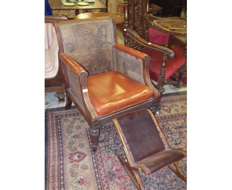 A Regency mahogany library chair with caned seat, back and side panels on reeded legs and a similar gout stool