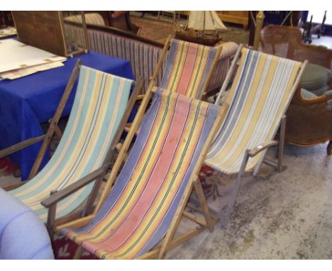 A vintage deck chair with striped canvas and three others similar