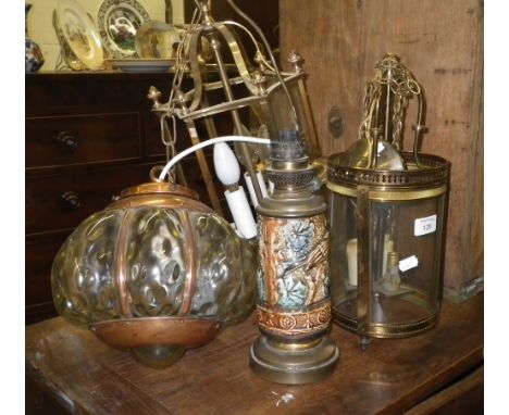 A circular brass hall lantern with curved glass panels, two similar and an oil lamp