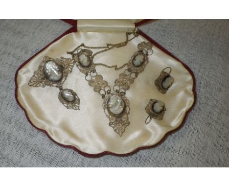 A white metal filigree and mother-of-pearl cameo jewellery suite comprising necklace, earrings and brooch