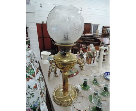 A brass oil lamp of traditional design converted to electric having etched globe shade