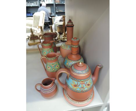 A selection of red stoneware in the Ellers Chinese style having enamel band decoration