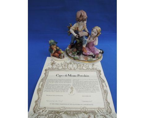 A Goebel Hummel figure modelled as boy with bird, a Capo di Monte figure boy and girl with accordian or Children At Play by B