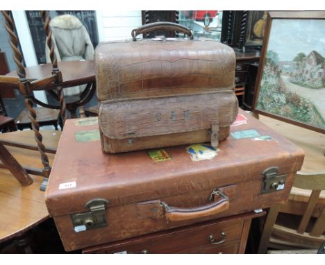 An Edwardian crocodile skin doctors case, a vintage leather suitcase with travel stickers, and a composite suitcase