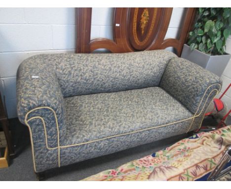 An early 20th century drop end sofa having late 20th century blue leaf upholstery on stub legs