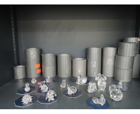 A shelf of Swarovski crystal animal ornaments, including koala, hedgehog, owl, etc, most boxed