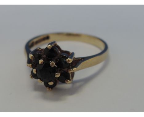 A ladies dress ring having a sapphire cluster on a 9ct gold loop