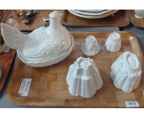 Four ceramic jelly moulds, varying designs including shelly, together with a Portmeirion white glazed egg crock.(B.P. 24% inc