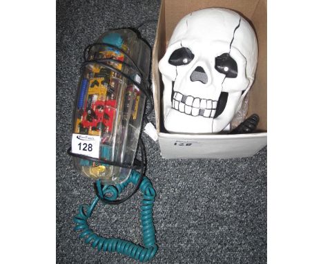 Modern skull telephone with light up red eyes, together with another clear plastic telephone. (2)(B.P. 24% incl. VAT) 