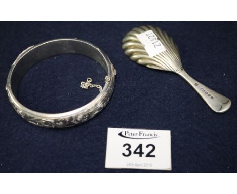 Silver plated shell shaped caddy spoon and an engraved silver hinged bangle. 1.6 troy ozs approx. (2) (B.P. 24% incl. VAT)