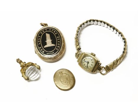 A gold memorial locket with black enamel decoration 'Not lost but gone before', a ladies gold mechanical watch with later exp