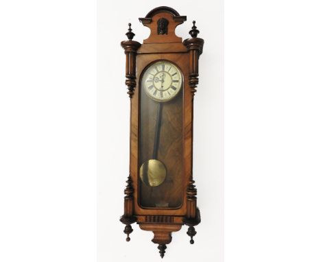 A late 19th century walnut Vienna regulator, fitted with enamel dial, with Roman numerals and visual pendulum, having arched 