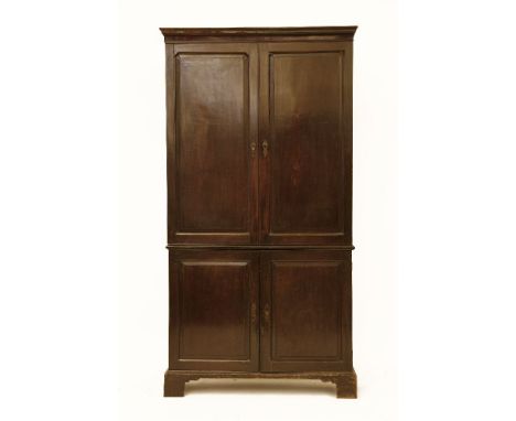 A George II and later mahogany estate cupboard, the upper section fitted with pigeon holes and drawers over cupboards beneath