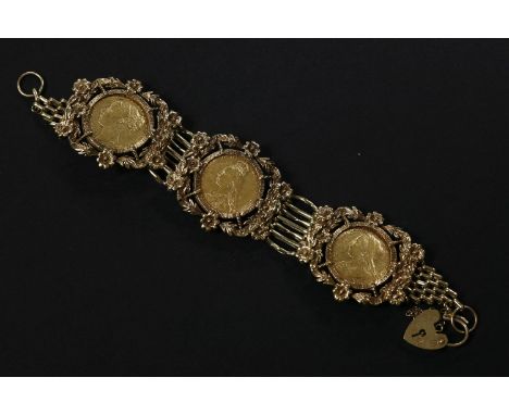 A gold seven row gate link bracelet, set with three gold sovereigns, dated 1900, 1901, 1871, all claw set to a floral and lea