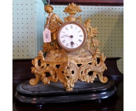 A gilt mantel clock, the circular enamel dial bearing Roman numerals, the body adorned with a lady on a scrolled rococo-style