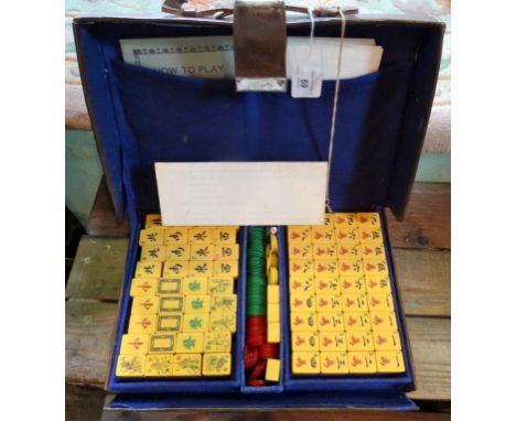 An early 20th century Chinese Mahjong set, retailed by the Chung Wah Company Shanghai, butterscotch bakelite tiles in two tie