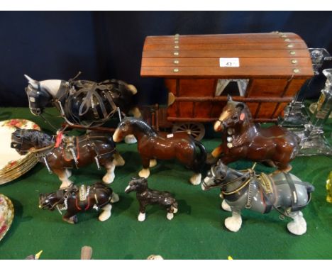 A collection of ceramic horse figurines, to include: a shire pulling a wooden caravan and others.