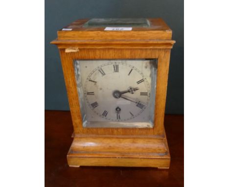 A walnut cased mantel clock, the silvered dial bearing Roman numerals, the case having glazed side, top and rear panels (24.5