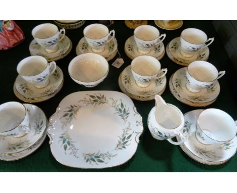 A Coalport part-tea service, a ten place setting comprising: trios, cake plate, open sugar bowl and cream jug, each having tu