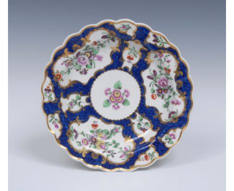 A Worcester shaped circular plate, painted with stylised flowers and sprigs within gilt fan and vase shaped cartouches, on a 