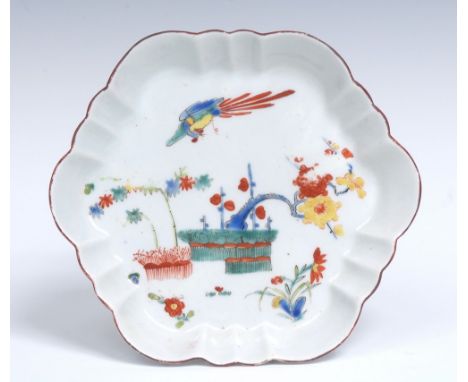 A Worcester fluted hexagonal teapot stand, painted in Kakiemon enamels with a long tailed bird in flight above prunus and bam