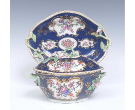 A Worcester quatrelobed dessert tureen, cover and stand.  painted with shaped panels of flowers, within gilded rococo borders