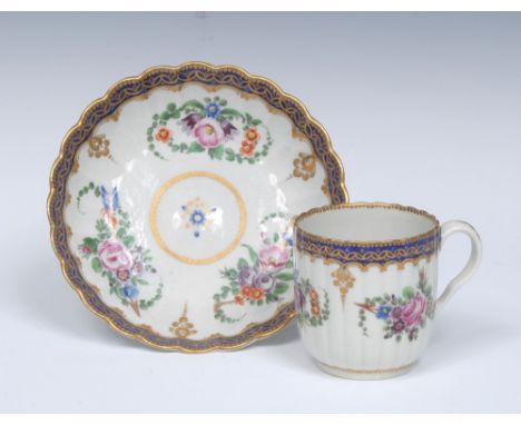 A Worcester Royal Marriage pattern reeded French shaped coffee cup and saucer, painted with three colourful sprays of flowers